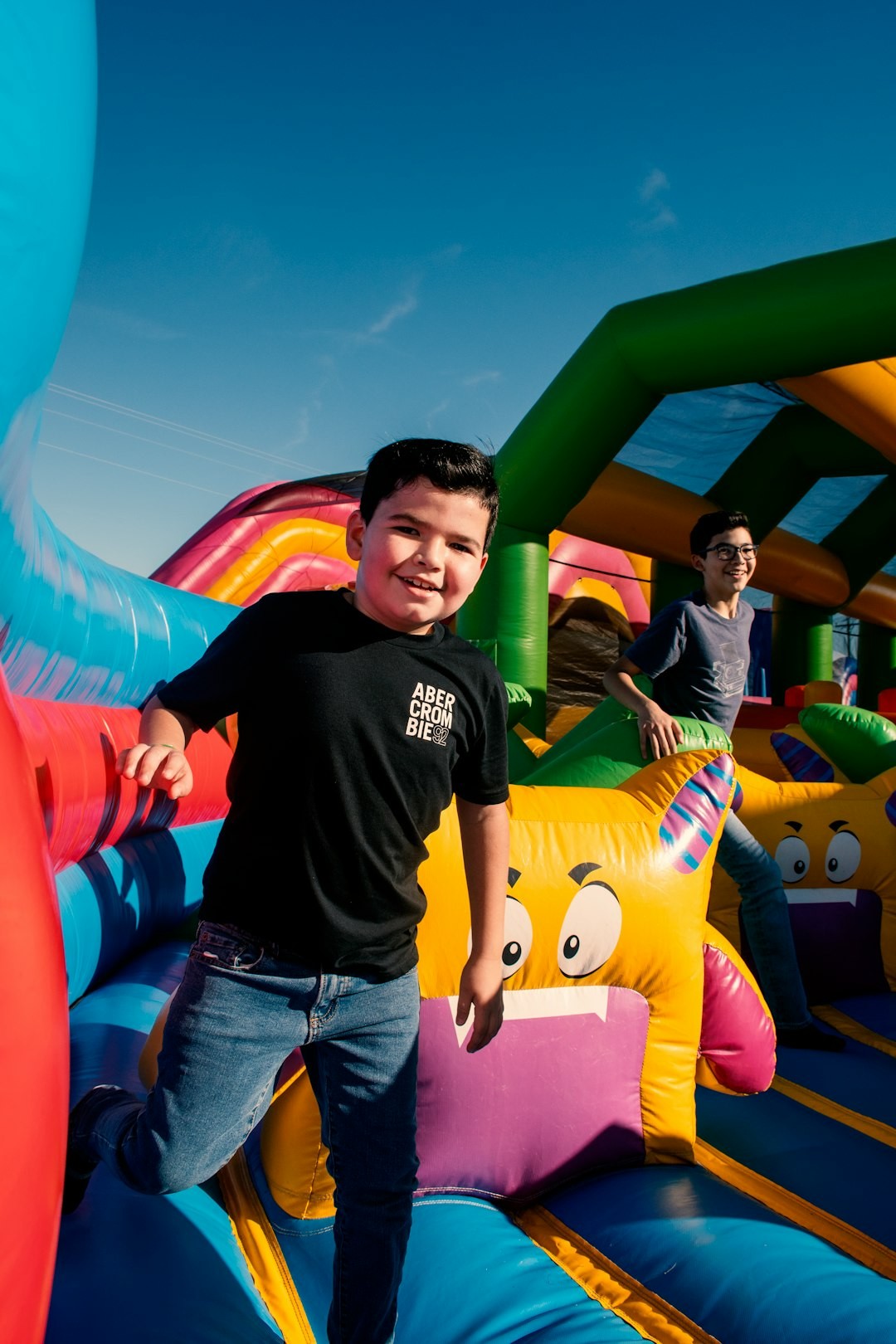 a young boy standing on top of a bouncy castle